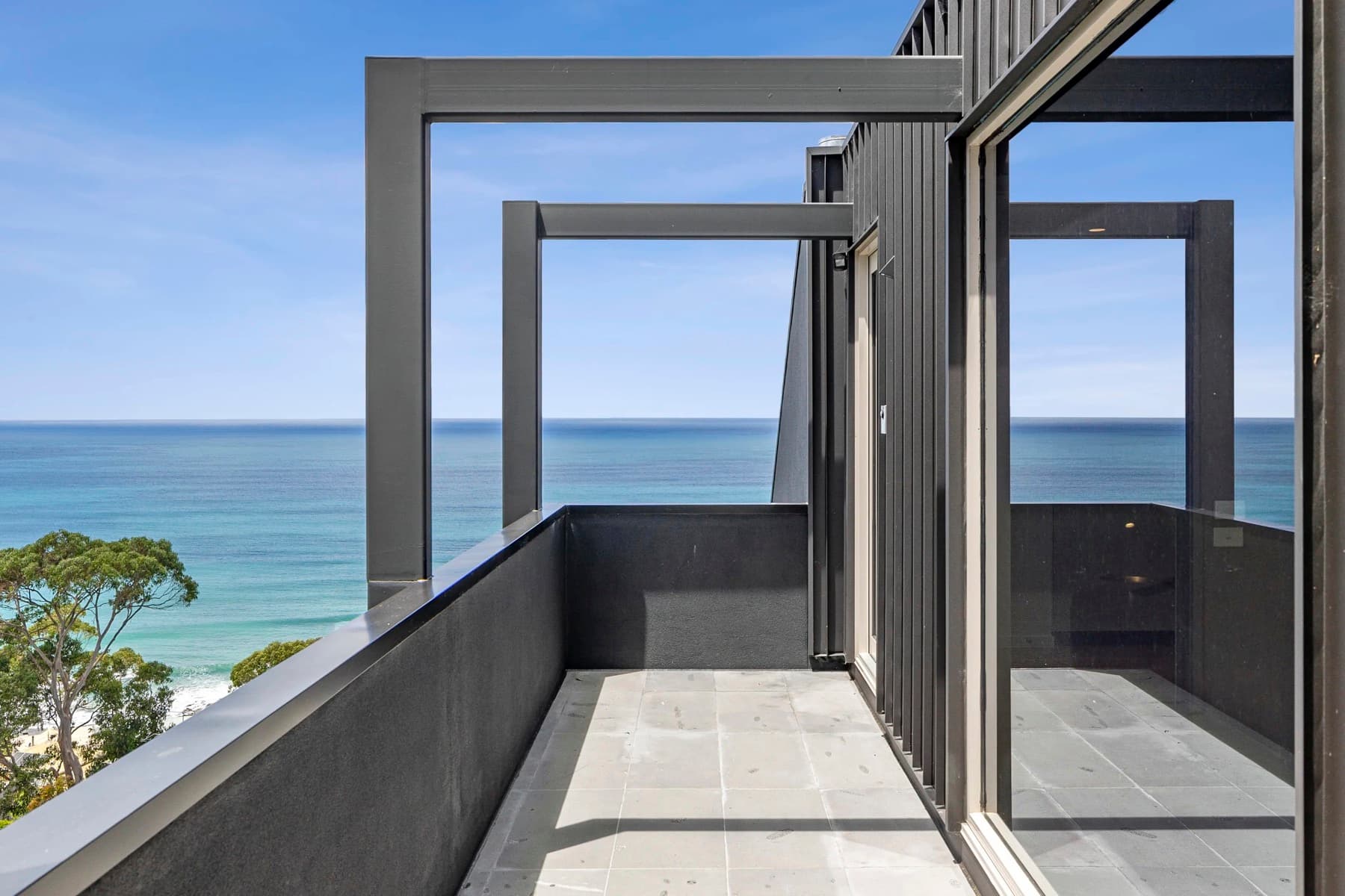 A charcoal-painted steel and cladding balcony overlooking the ocean